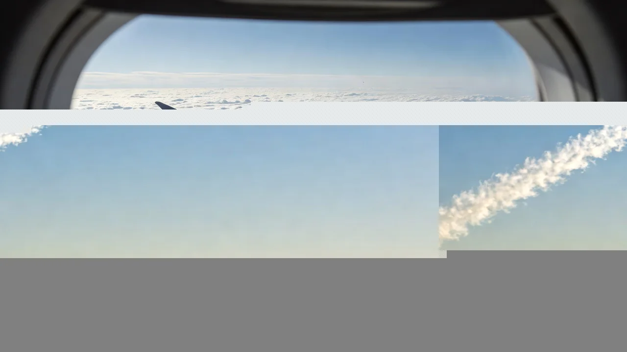 An airplane climbing steeply into a bright morning sky with a long contrail